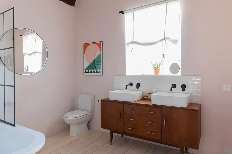 Cuarto de baño en una casa rural francesa con aparador de mediados de siglo