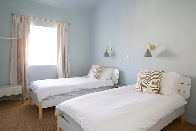 Chambre à deux lits dans un gîte français aux murs bleus relaxants  