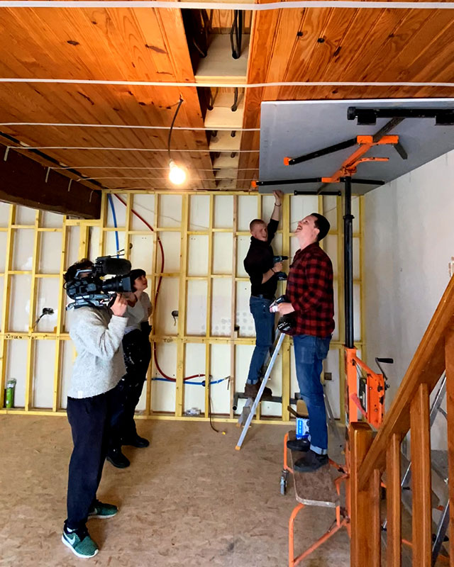 A cameraman filming renovation works for a reality tv programme