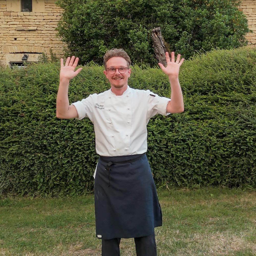 Chef Ritchie Stainsby waving to the camera after a long service at a vegan food retreat in France
